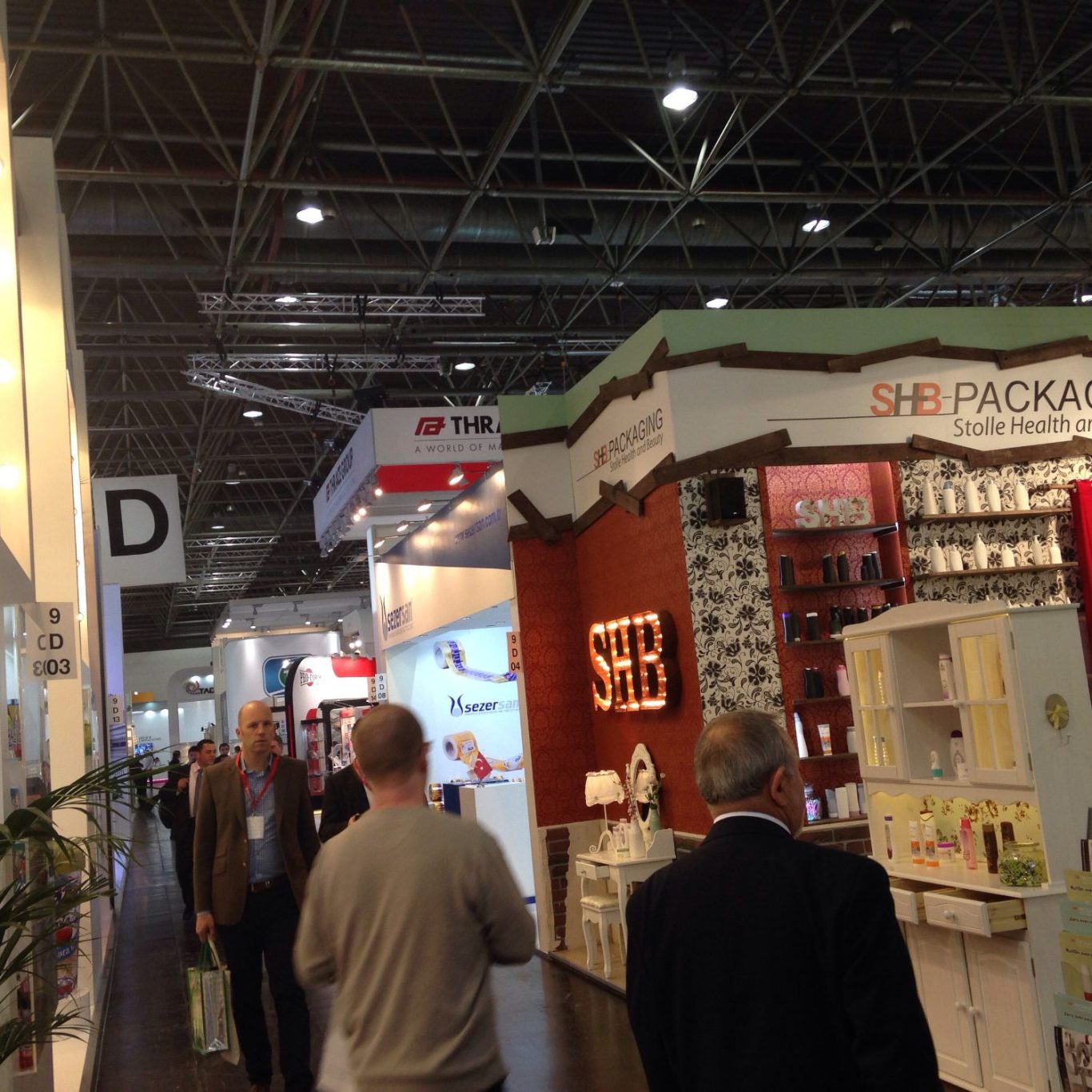 Organization Overview of a trade show aisle with the booths of different companies and the visitors.